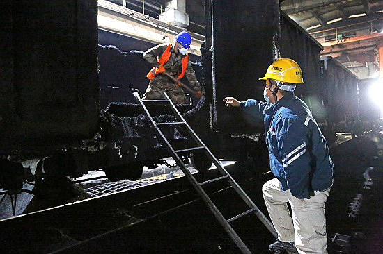 1706066347862055200.jpg 馬頭熱電公司燃料質(zhì)檢部接卸班邢濤指揮協(xié)調(diào)卸煤隊(duì)人員清卸車廂內(nèi)的凍煤 - 副本.jpg