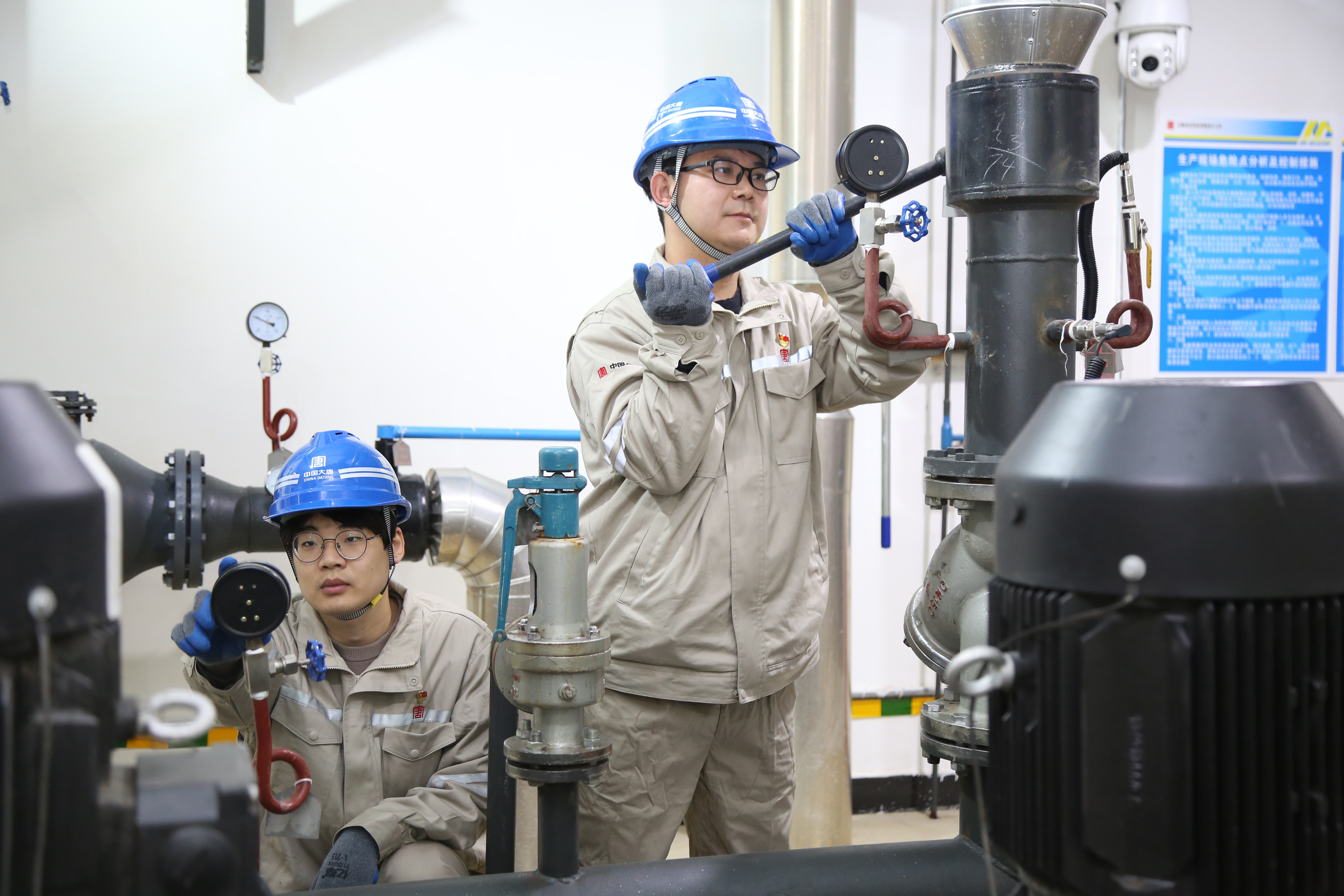 1730098831048035622.jpg 保定供熱公司一分公司維護班班長張浩(右一)在熱力站開展注水試壓工作.jpg